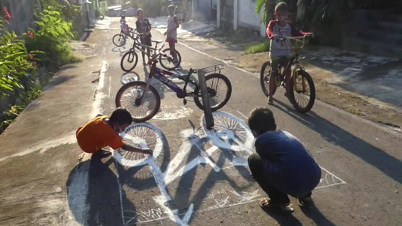 Kinderen tekenen de schaduw van een fiets